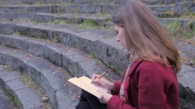 Onun defterini notlar yazma merdivenlerde, otururken Üniversitesi'nde ders hazırlama çekici genç kız öğrenci. Bir dizüstü bilgisayarda el ile genç kız