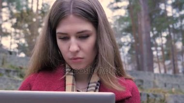 Parkta tablet kullanan genç kadın. Bir tablet açık havada bir parkta Tarih kullanan kadın. Parkta tablet üzerinde çalışan genç iş kadını