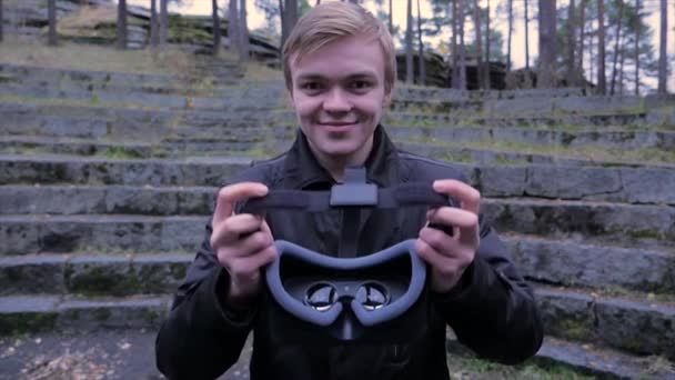 Young Man geven een Virtual Reality Headset in het park. Young Man geven een Virtual Reality Headset in de outdoor — Stockvideo