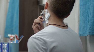 Genç adam bir tek jilet yanağını tıraş ile kapatın. Adam banyoda tıraş ve kendini kesti. Yara izi