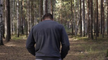 Kas yapı ayakta spor zemin arka plan ile uygun genç adam görünümünü arka. Avcı kopya alanı arıyor. Kaslı erkek geri