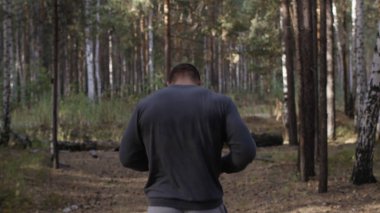 Orman yolda çalışan kas Çalıştırıcısı. Arkadan Görünüm. Orman yolda koşan atletik adam. Sonbahar orman ile iz üzerinde koşan atletik adam