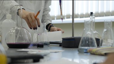 Deneme yapıyor laborant laboratuarında. Erkek tıbbi ya da bilimsel laboratuvar araştırmacı mavi sıvı ile sınamaları gerçekleştirir. Şişeler laboratuvar ile çalışan bilim adamı