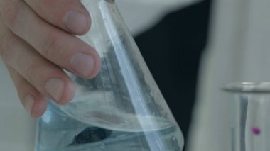 El sıvı kimyasallar şişesi dökme. Kimyasal karıştırma laboratuar işçisi