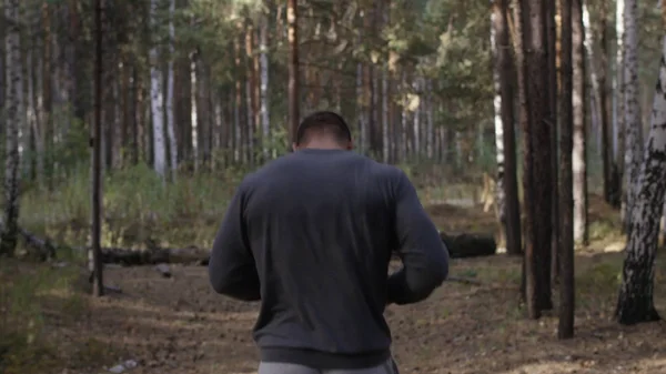 Gespierde loper uitgevoerd op weg door het bos. Achteraanzicht. Atletische man loopt op weg door bos. Atletische man loopt op spoor door herfst bos — Stockfoto