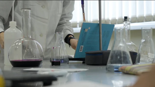 Τεχνικός εργαστηρίου κάνει πείραμα στο εργαστήριο. Αρσενική ιατρική ή επιστημονική εργαστήριο ερευνητής εκτελεί δοκιμές με μπλε υγρό. Επιστήμονας που εργάζεται με φιάλες στο εργαστήριο — Φωτογραφία Αρχείου