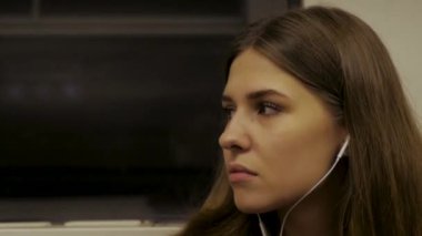 Genç kadın metroya biniyor ve kulaklıklar müzik dinlemek. Yolda müzik ile. Kulaklıklar müzik dinlemek metro tren, genç kadın rides