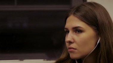 Genç kadın metroya biniyor ve kulaklıklar müzik dinlemek. Yolda müzik ile. Kulaklıklar müzik dinlemek metro tren, genç kadın rides