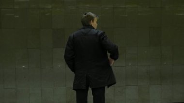 Metro istasyonunda yalnız genç adam arkadan. Genç adam bir tren metro, dikiz bekler