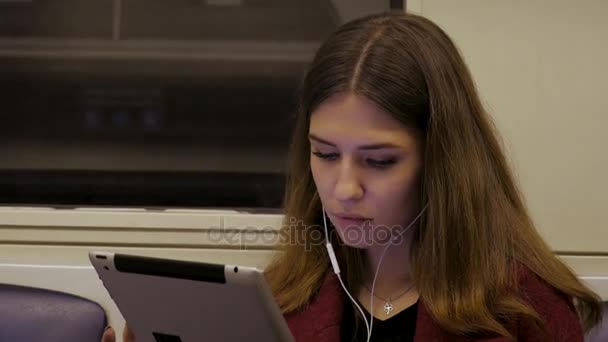 Mladá podnikatelka cestování vlakem tabletový počítač. Mladá žena v metru pracuje v tabletu — Stock video