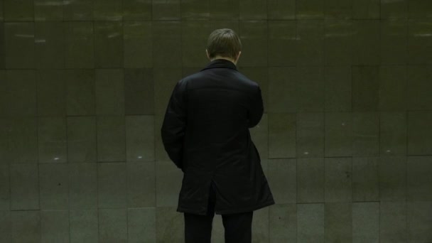 Eenzame jonge man van achter bij metrostation. Jonge man wacht op een trein in de metro, achteraanzicht — Stockvideo