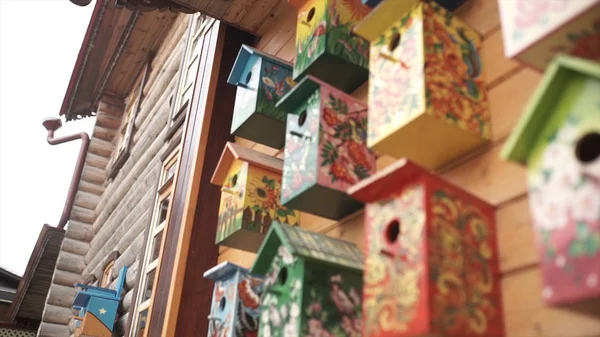 Casas de pássaros coloridas. Casa de pássaros de madeira artesanal em casa de tronco. Casas de pássaros na parede. Bairro. Casa de pássaro de madeira em estilo vintage — Fotografia de Stock