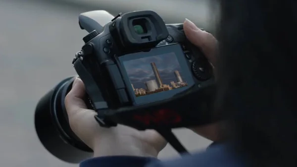 Photographer girl shooting images. woman hands holding camera taking photos. Girl looks at the camera screen — Stock Photo, Image