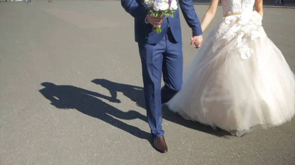 St petersburg, russische Braut und Bräutigam zu Fuß entlang. Das Brautpaar geht auf dem Platz in der Nähe des Winterpalastes und hält Händchen. Händchenhaltend spazieren Braut und Bräutigam über den Petersplatz — Stockfoto