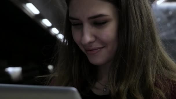 Chica usando una tableta y esperando el tren en la estación de metro. chica morena se queda en el metro y utilizando touchpad. Gadget de moda. El concepto está siempre en contacto . — Vídeos de Stock