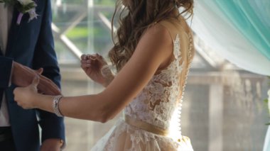 Portre bir altın alyans mamülleri parmak koyarak bir gelin. Alyans ve gelin ve damat. Genç Düğün çifti töreninde. Gelin Damat parmağında yüzük giymek.