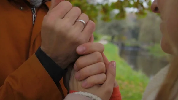 男人温暖女人的手。新娘和新郎手牵手, 在公园里互相温暖。男人和女人牵手。温暖的手. — 图库照片