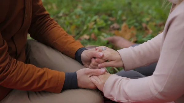 Pareja joven sentados juntos en un parque de verano y hacer un picnic en una manta de picnic a cuadros. pareja en el parque sentado en el césped, buen tiempo juntos. pareja relajándose en la hierba —  Fotos de Stock