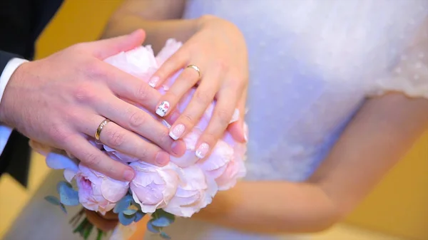 新婚夫妇手与结婚戒指。新娘与新郎同花或婚礼花束上的结婚戒指。新婚夫妇手与结婚戒指 — 图库照片