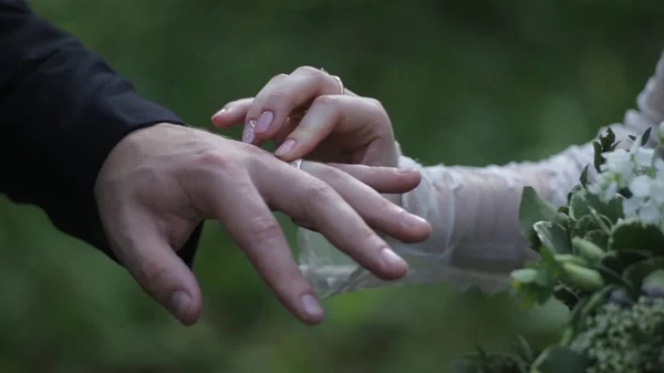 新娘在新郎的手指上戴上戒指。新郎给新娘的手指的结婚戒指。结婚戒指的双手。birde 新郎的手指上戴着的戒指 — 图库照片