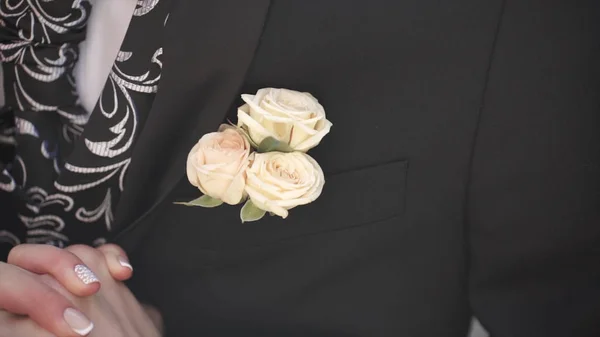 Flor de cravo em um bolso. a flor no bolso do casaco. alfinete com flores brancas decorativas presas na jaqueta dos noivos. flor boutonniere no bolso do noivo na cerimônia de casamento — Fotografia de Stock