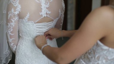 Sabah gelin. Nedime elbisesinin kadar bağlama gelin yardım. Kız elbise tutturmak için gelin yardım