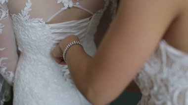 Sabah gelin. Nedime elbisesinin kadar bağlama gelin yardım. Kız elbise tutturmak için gelin yardım