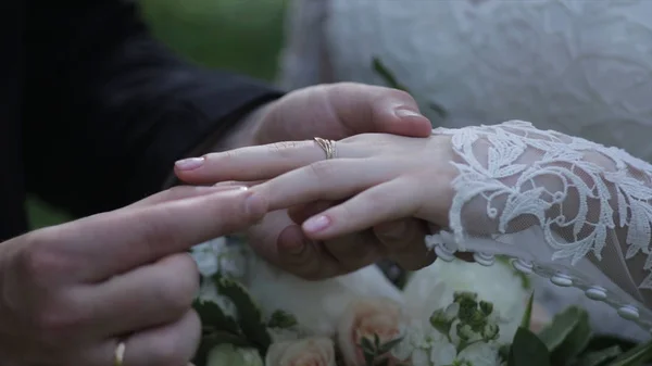 新娘在新郎的手指上戴上戒指。新郎给新娘的手指的结婚戒指。结婚戒指的双手。birde 新郎的手指上戴着的戒指 — 图库照片