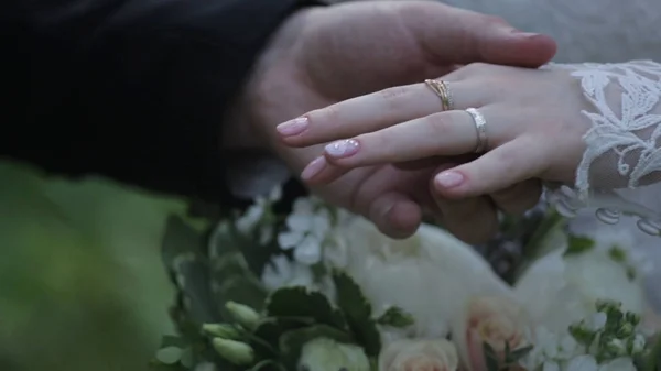 Bague d'usure de la mariée sur le doigt du marié. Le marié met l'alliance au doigt de la mariée. mains de mariage avec anneaux. oiseau porte l'anneau sur le doigt du marié — Photo