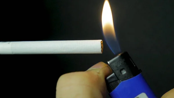 Kézi világító könnyebb cigaretta Vértes. Fekete háttér előtt égő cigaretta. Cigaretta closeup, fekete háttér — Stock Fotó