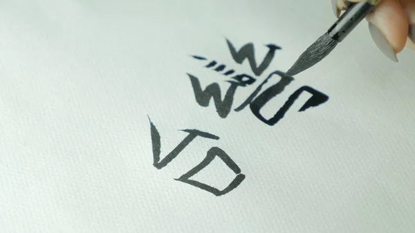 Γυναικεία χέρια γράφοντας Κινέζικη Ιερογλυφικό. Γυναικείο χέρι που κρατά μια βούρτσα γραφής Κινεζική καλλιγραφία χαρακτήρες, κοντινό πλάνο — Φωτογραφία Αρχείου