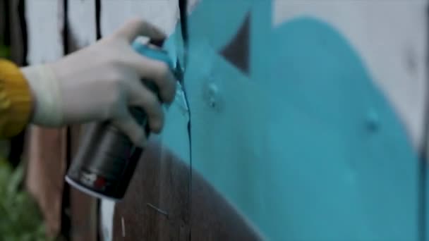 Conceito de pessoas, arte, criatividade e cultura juvenil - close-up de grafite desenho à mão com tinta spray na parede da rua. Spraying graffiti close-up — Vídeo de Stock