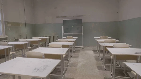 Пустой класс с деревянными столами, белыми и зелеными досками в школе. пустой класс. Заброшенный школьный класс со школьными столами и доской — стоковое фото