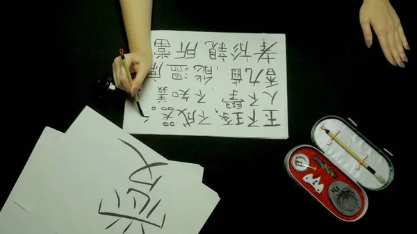 Weibliche Handschrift chinesische Kalligraphie mit Pinsel und Tinte auf Reispapier. Nahaufnahme mit Pinsel in der Hand beim Schreiben von Kalligraphie. Chinesische Malerei und Kalligraphie — Stockfoto