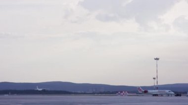 Havaalanı, uçak kalkış, peyzaj üzerinde. Yolcular uçağın havaalanı pist güzel günbatımı ışık için açılış. Beyaz yolcu uçağı Havaalanı uzak iniyor