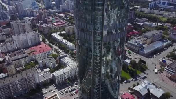 Flygfoto över reflekterande office skyskrapor och trafikstockning i en moderna finansdistriktet. Speglar av himlen och stadsbilden på kvällen tid med kurvan av glas. Utomhus av moderna byggnad — Stockvideo