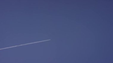 Büyük yolcu süpersonik uçak için açık mavi gökyüzü, beyaz uzun iz bırakarak yüksekten uçuyor. Mavi bir gökyüzü beyaz bulutlarda uçan uçak. Mavi gökyüzü uçan uçak