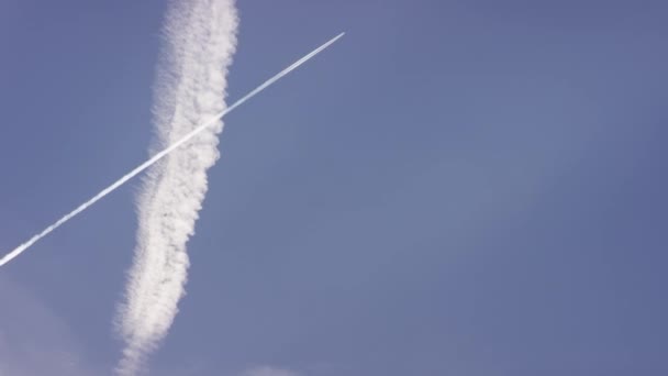 Grote personenauto supersonische vliegtuig vliegt hoog in de heldere blauwe hemel, lange witte spoor. Vliegtuig vliegen in witte wolken in een blauwe hemel. Vliegtuig vliegen blauwe hemel — Stockvideo