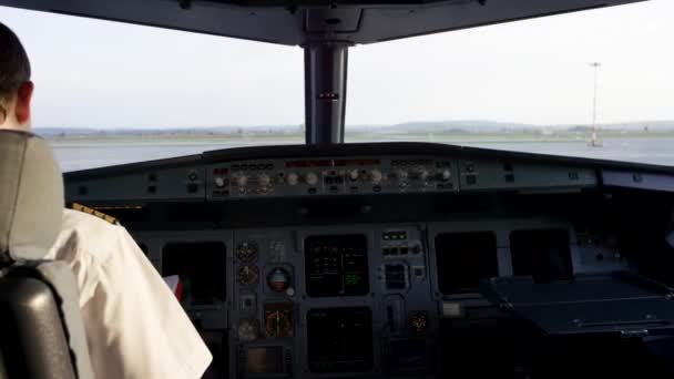 Visão traseira dos controles de operação do piloto do jato corporativo. Capitão no cockpit da aeronave, a preparar-se para a partida do voo. Concentrando-se em seus epauletos piloto . — Vídeo de Stock