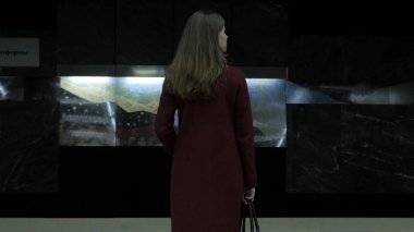 İçin gelen tren bekleyen kız Metro istasyonunda. Dikiz tren istasyonunda bekleyen kız. Tren geldiğinde