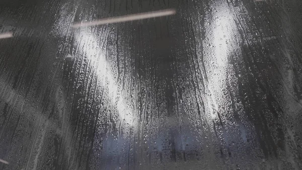 Water drops on glass. Drops of rain on a black glass background. Natural Pattern of raindrops. Rain in the city. Effect from raindrop make vapor on the window