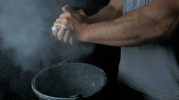 Talc sports. Closeup of a muscular man ready to workout. male powerlifter hand in talc and sports wristbands preparing to bench press. Hands in chalk. male powerlifter hand in talc