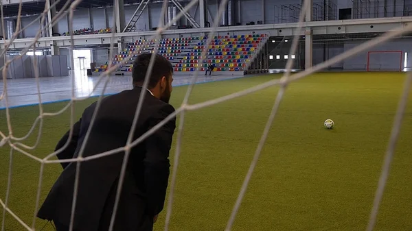 Zakenman spelen footbal op groene veld zoals een keeper. Close up van een man formele pak dragen op het veld terwijl een voetbal — Stockfoto