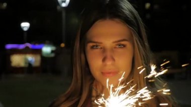 Maytap elinde tutan genç gülümseyen kız. Ağır çekimde tutan kız portresi parıldıyor