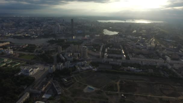 Vista aérea de la ciudad con encrucijada y caminos, casas, edificios, parques y estacionamientos, puentes. Paisaje urbano — Vídeos de Stock