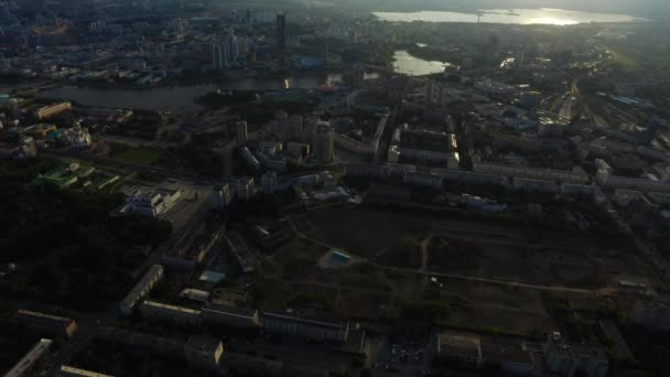 Antenn med stadsutsikt och crossroads och vägar, hus, byggnader, parker och parkeringsplatser, broar. Urbana landskap — Stockvideo