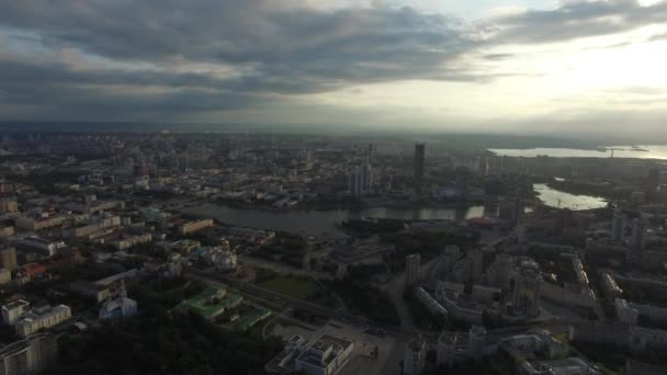 Bela e incrível vista sobre a cidade. Você pode ver as ruas, as casas, o grande arranha-céu, os raios de sóis irrompem através das nuvens — Vídeo de Stock