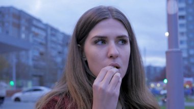 Bir genç kızın kasaba meydanında yemek lokanta var. Kentsel bir sokakta duran ve patates kızartması yiyen genç kadın. Genç kadın sokakta lokanta ayakta yemek