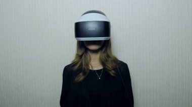 Aamazed genç bir kadın Vr deneyimi sırasında hava dokunmadan. Gelecek şu andır. Onun Vr kulaklık ayarlama ve evde otururken gülümseyen çekici genç kadın