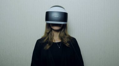 Aamazed genç bir kadın Vr deneyimi sırasında hava dokunmadan. Gelecek şu andır. Onun Vr kulaklık ayarlama ve evde otururken gülümseyen çekici genç kadın